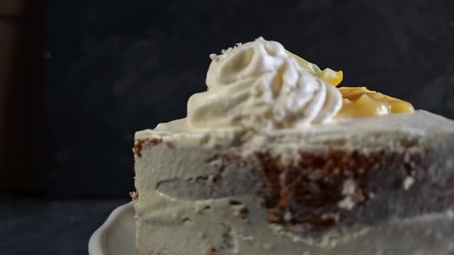 A Delicious Slice of Lemon Blueberry Cake with Whipped Cream Frosting Between Layers Spinning on a White Plate