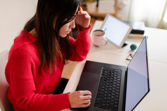 Teleworking woman stressed about laptop malfunction 