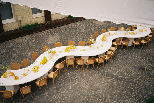 Film Photo of Wavy White Wedding Table with Yellow Fruit Decor