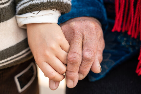 Hands of grandchild and grandparent