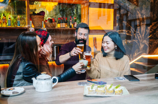 Friends toasting drinks, celebrating happy social gathering