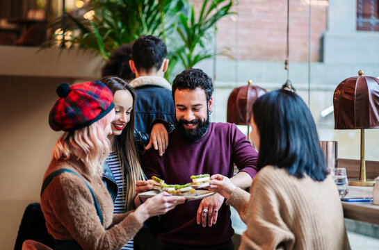 Friends sharing food and socializing at bar restaurant