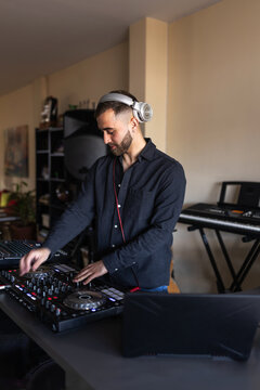 Dj mixing music at home studio with headphones