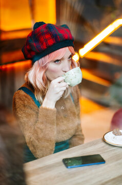 Woman enjoying coffee break in plaid beret