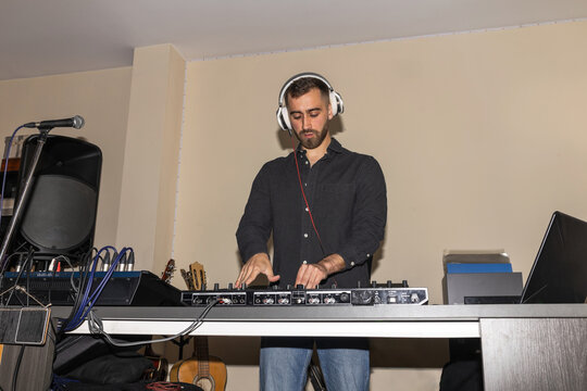 Bearded man dj mixing music at home party