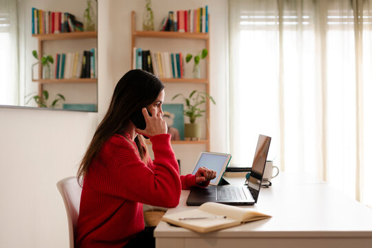 Multitasking teleworker on Phone at home office