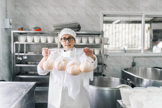 Woman artisan cheesemaker producing fresh cheese curds