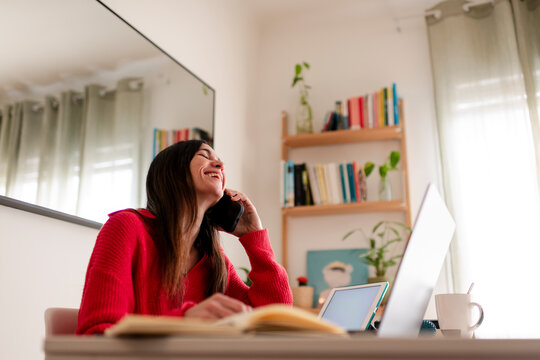 Laughing Woman Enjoying Phone Call at Home Desk