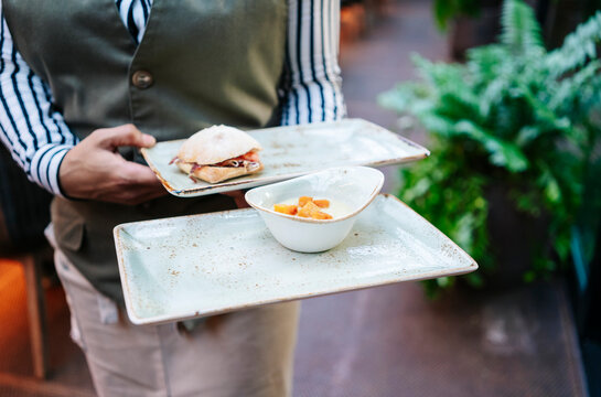 Waiter carrying tapas and small appetizers in a restaurant