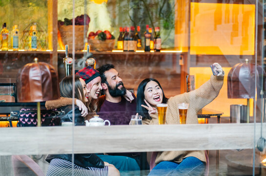 Diverse friends taking a happy selfie at bar counter