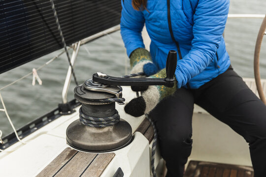 Close Up of Woman Operating a Manual Winch on Yacht