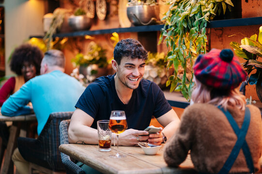 Young man smiling and talking at bar restaurant