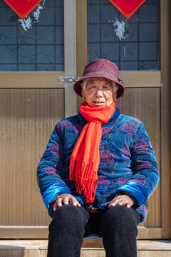 Elderly woman sitting at doorway
