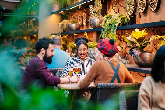 Friends enjoying drinks and conversation in bar restaurant