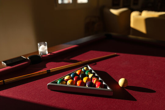 Billiard table with balls and drink in dramatic light