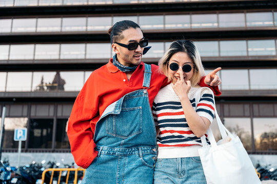 Asian couple laughing and enjoying urban fashion lifestyle