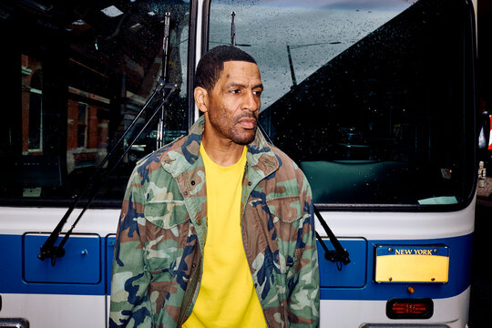 Man stands near a city bus in Brooklyn