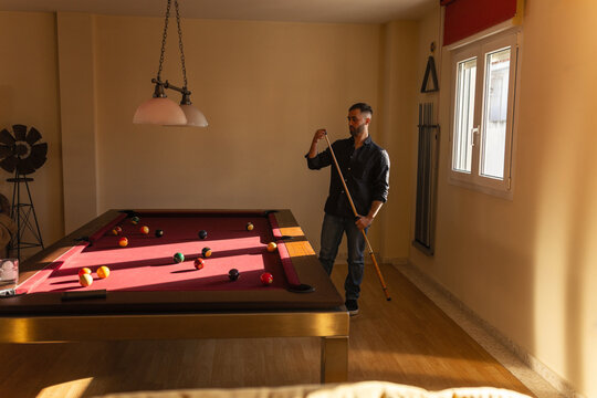 Man preparing billiard cue before playing
