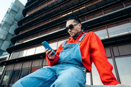 Man wearing streetwear checking smartphone in urban setting