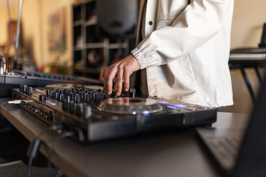 Close up of dj hands mixing music on controller
