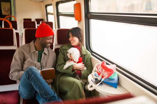 Couple Enjoys Train Travel With Their Dog and a Book
