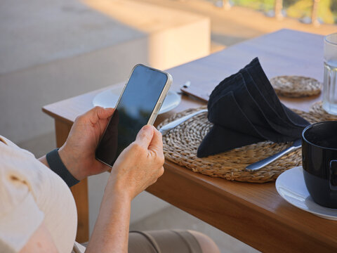 Person Using a Smartphone at Restaurant Table