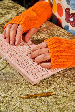 close view of a man typing with orange gloves