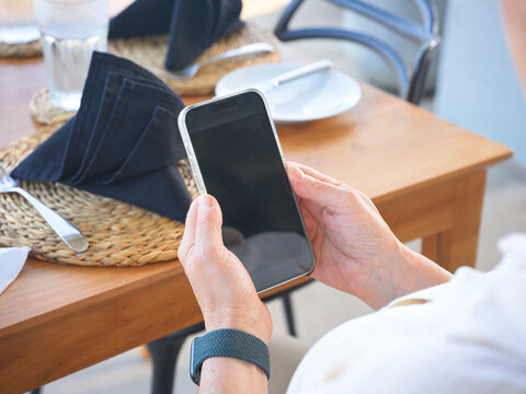 Person Using a Smartphone at Restaurant Table