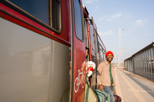 Excited Couple Step Off Train With Luggage and Dog