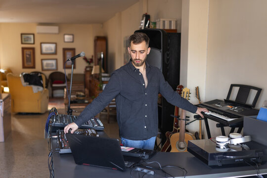 Man in home music studio with piano and dj equipment