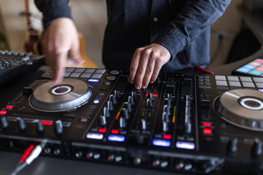 Blurred motion of dj hands mixing with colorful lights