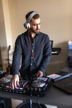 Dj mixing music at home studio with headphones