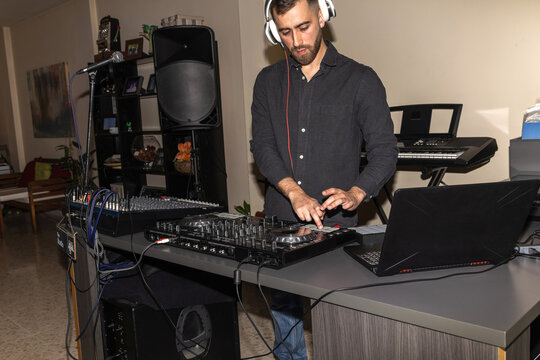 Bearded man dj mixing music at home party