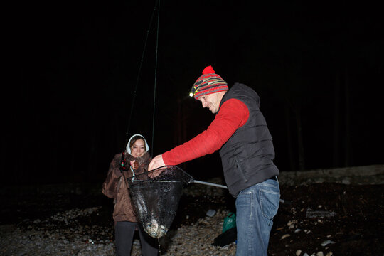 Man and woman catch crabs at night