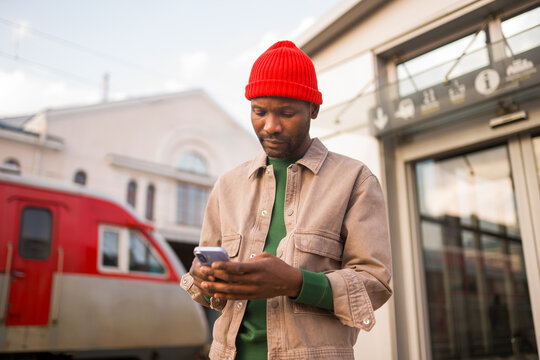Man Checks Phone at Train Station 