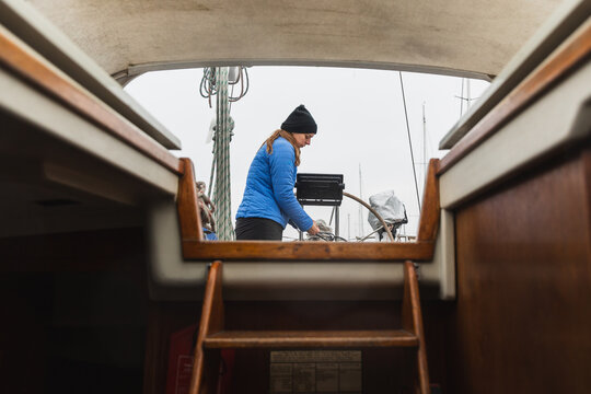 Female Sailor Working on Sailboat Deck Seen from Cabin Interior
