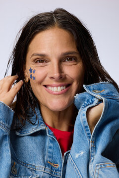 Smiling Woman With Star Stickers Poses in Denim Jacket