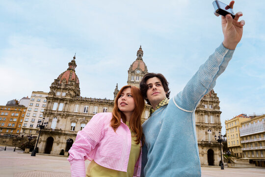 Couple taking smartphone selfie in historic European plaza