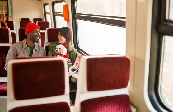 Couple Enjoys Train Ride With Small Dog 