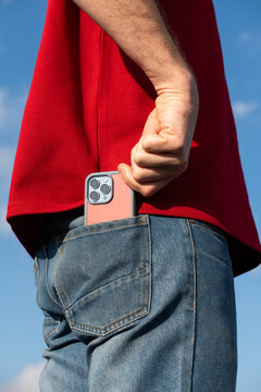 Man Holds Phone in Pocket Outdoors 