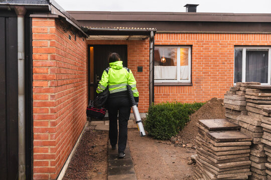 Professional Technician Carrying Tools to Residential Worksite