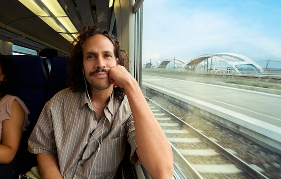Man looking out train window during trip in Antwerp Belgium