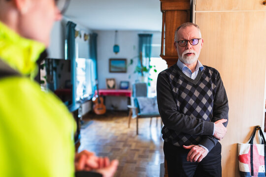 Technician Discussing Service Results with Senior Homeowner Indoors