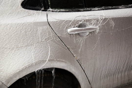 Car Door Covered in Thick Ice and Frozen Rain After Winter Storm