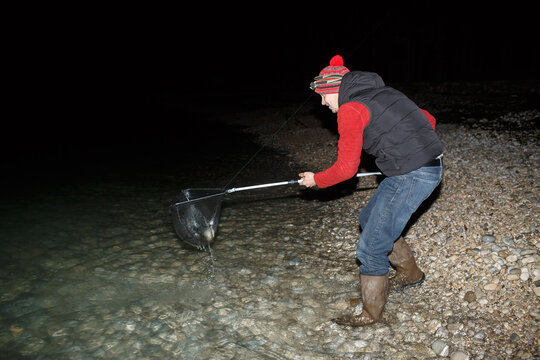 Man with a landing net on a night crabbing trip