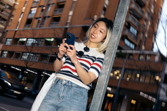 Young asian woman using smartphone in urban setting