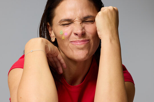 Woman Shows Playful Expression With Stickers on Her Face