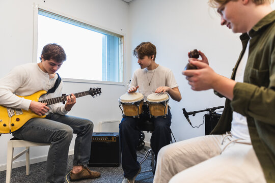Creative Friends Having a Music Jam Session with Guitar and Bongos
