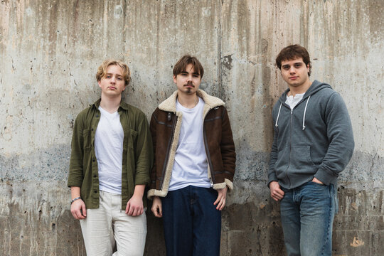 Three Diverse Young Friends Posing Together Against Urban Wall