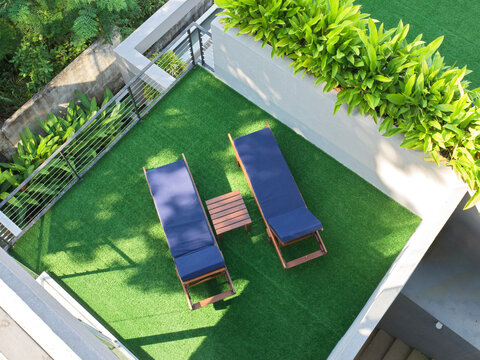 Two Lounge Chairs on Green Grass in a Private Outdoor Space